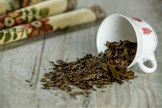 Tasse de thé avec des feuilles de thé renversées sur une table